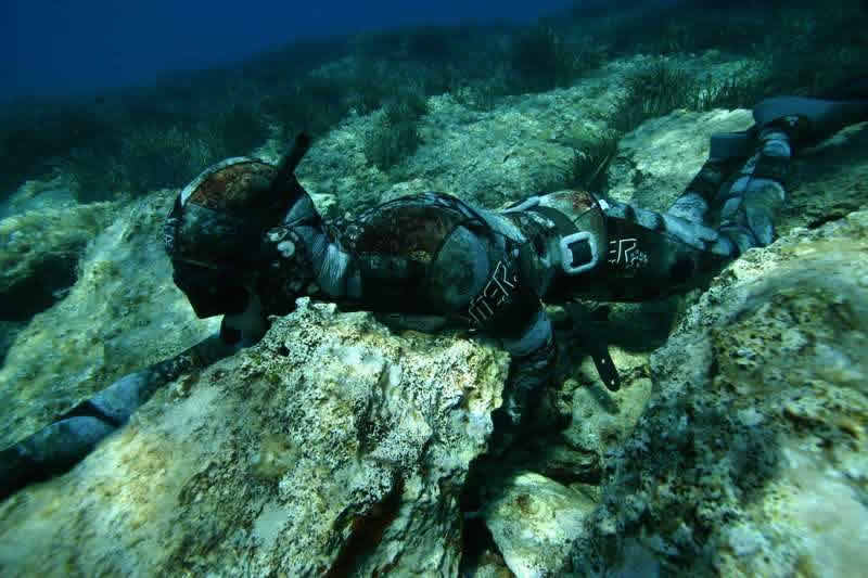 Camo coud be important, but the spearfishing is hiding himself using the bottom.